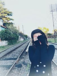 Man on railroad track against clear sky