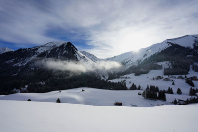 Scenic view of snow covered mountains against sky