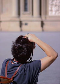 Rear view of woman standing against built structure