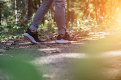 Low section of woman walking on footpath