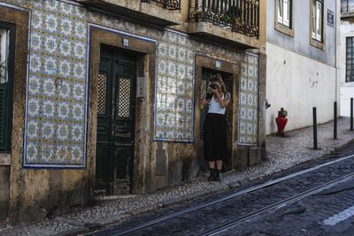 Woman standing on railroad track by building