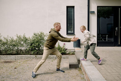 Full length of father and son playing together at back yard