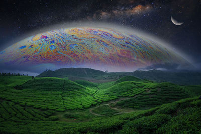 Scenic view of field against rainbow in sky