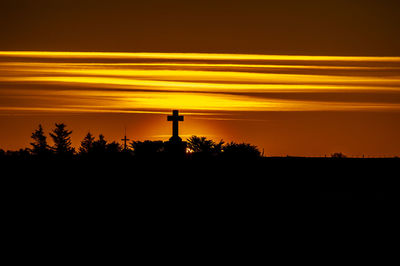 Scenic view of silhouette landscape against orange sky