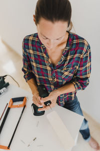 High angle view of woman using smart phone on table