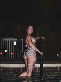 Portrait of young woman in bikini standing