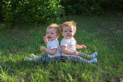 Siblings sitting on lawn