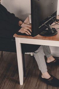 Low section of man sitting on table