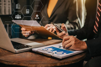 Midsection of man using laptop on table