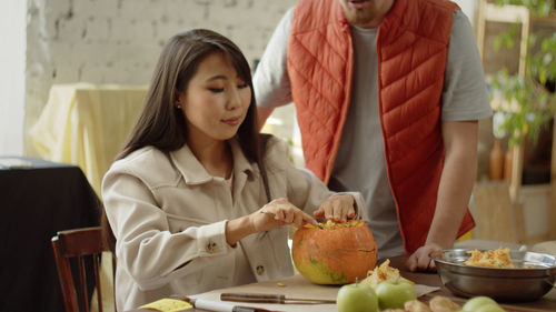 Portrait of young woman having food at home