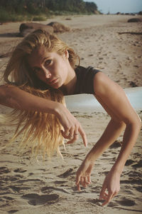 Portrait of woman holding mirror at beach