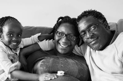 Portrait of happy family on sofa at home