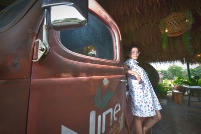 Portrait of smiling young woman standing against wall