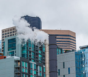 Low angle view of smoke emitting from chimney against sky