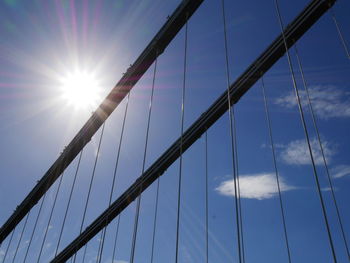 Low angle view of suspension bridge against blue sky