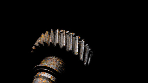 Low angle view of metallic structure against black background