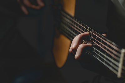 Midsection of man playing guitar