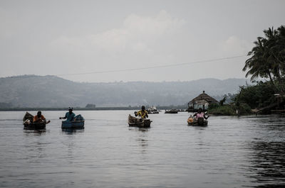 People sailing on river against sky