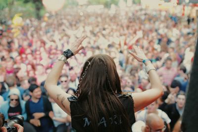 Rear view of woman with arms raised