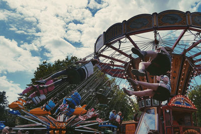 Low angle view of carousel against cloudy sky