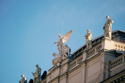 Low angle view of statues on building against sky