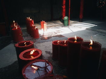 Lit candles in row on floor