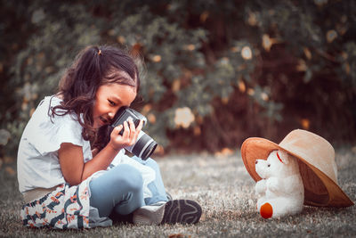 Girl playing with toy sitting outdoors