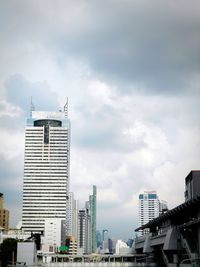 View of skyscrapers against cloudy sky