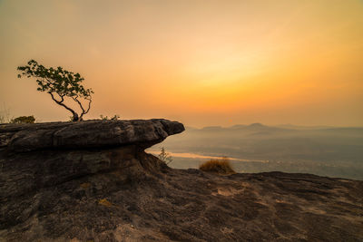 Rock formation on land against sky during sunset