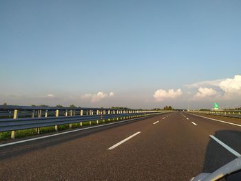 Road by bridge against sky in city