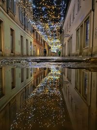 Illuminated buildings by canal at night