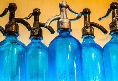 Close-up of empty bottles against blue background