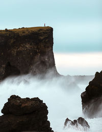 Rock formations in sea against sky