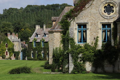 Trees by historic house against sky