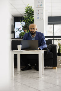 Side view of businessman using laptop at office