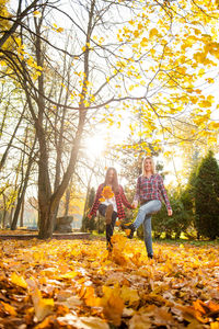 Woman with umbrella against autumn trees