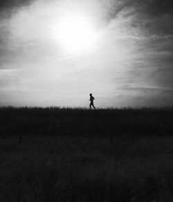 Silhouette of woman standing on field