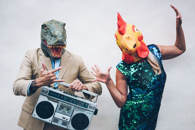 People in mask dancing against wall