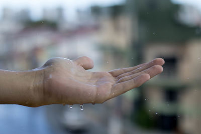 Cropped hand of man during rain