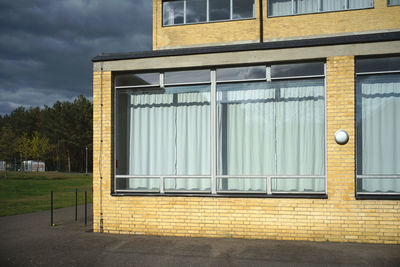 Bauhaus style building on field against dramatic sky