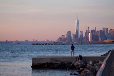 City skyline by sea against sky