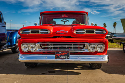 Red vintage car on road against sky