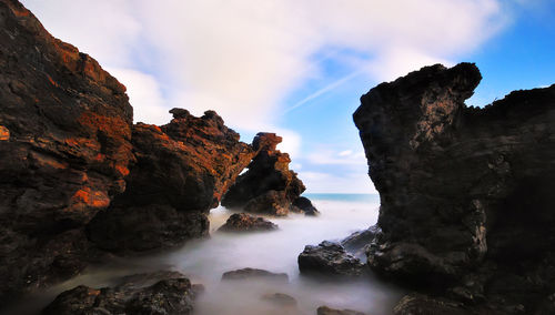 Low angle view of rocks in mountains against sky