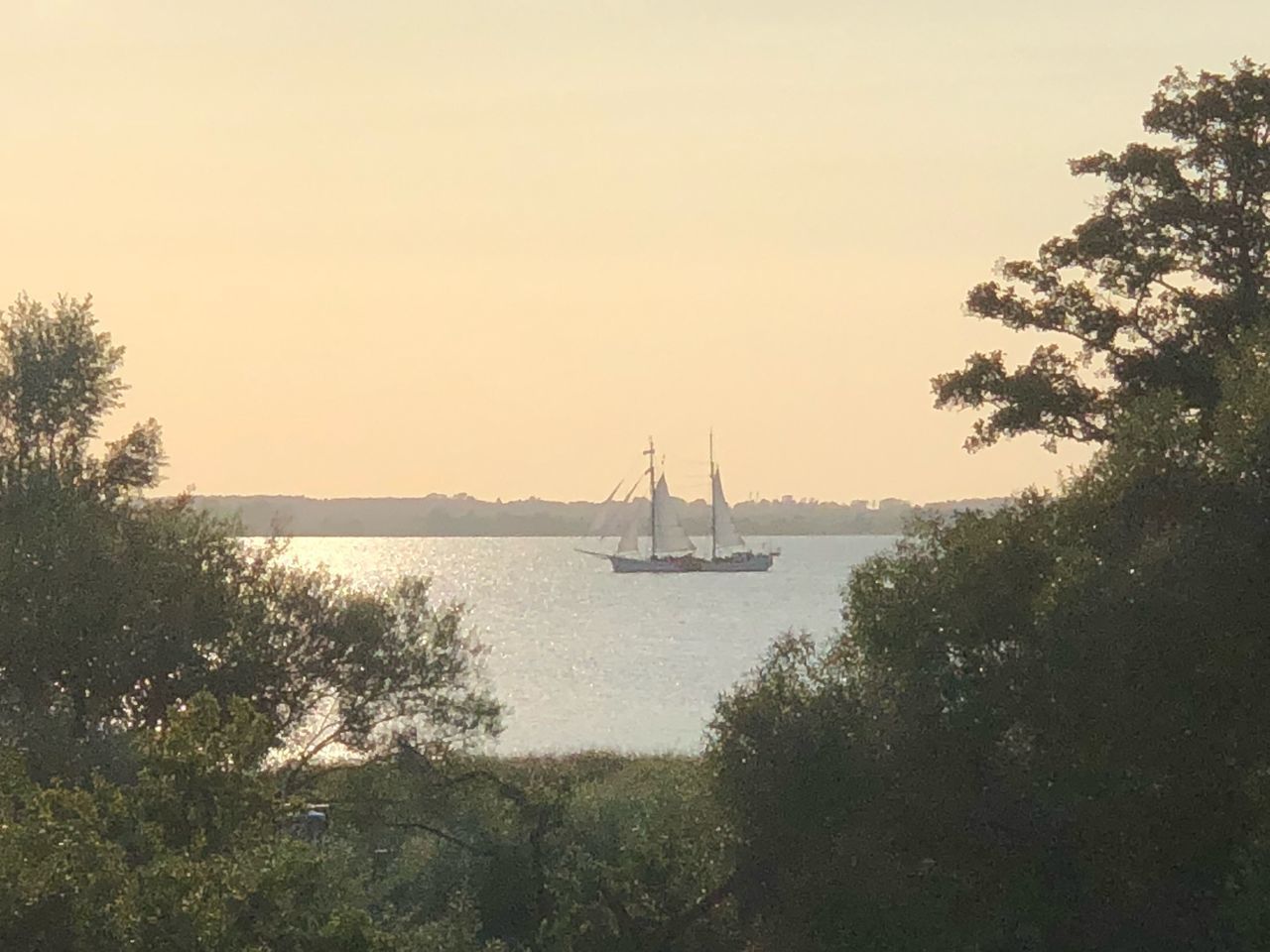 SAILBOAT SAILING ON BAY AGAINST SKY