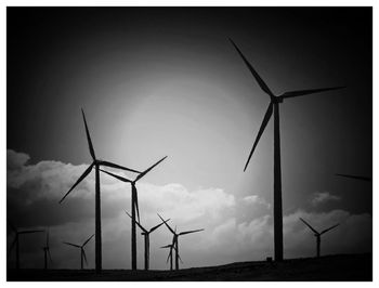 Traditional windmill on field against sky