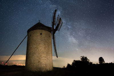 Low angle view of windmill against sky at night