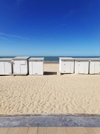 Scenic view of beach against clear blue sky