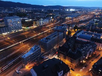 High angle view of illuminated street amidst buildings at night