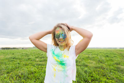 Portrait of woman standing on field against sky