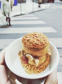 Person holding bowl of baked pastry with fig